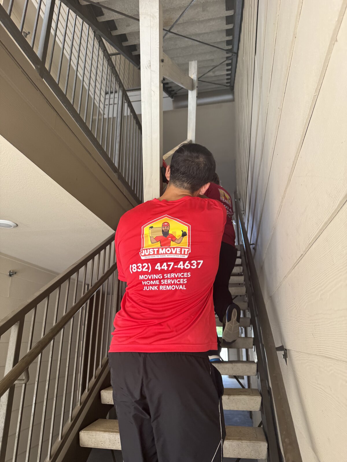 Just Move It crew carrying items up an apartment stairwell